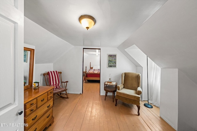 sitting room with light hardwood / wood-style floors and vaulted ceiling