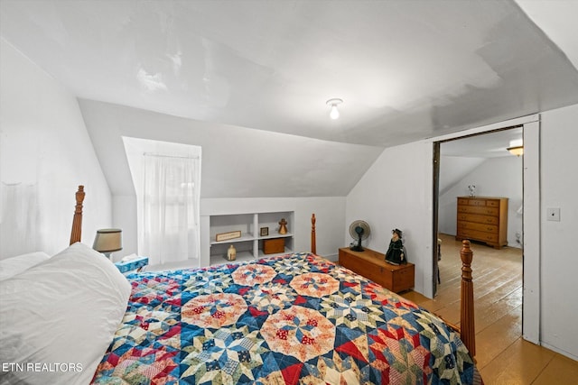 bedroom with vaulted ceiling and light hardwood / wood-style flooring