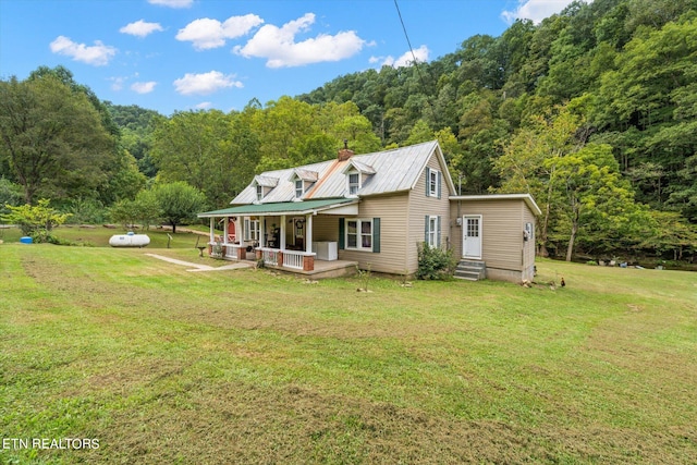 back of house featuring covered porch and a lawn