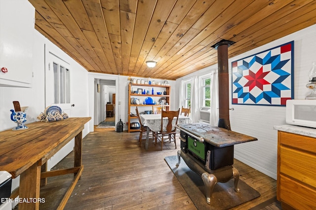 interior space with wood ceiling, a wood stove, and dark hardwood / wood-style floors