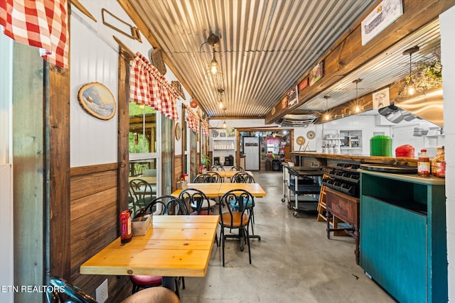 dining area featuring wooden ceiling and concrete floors