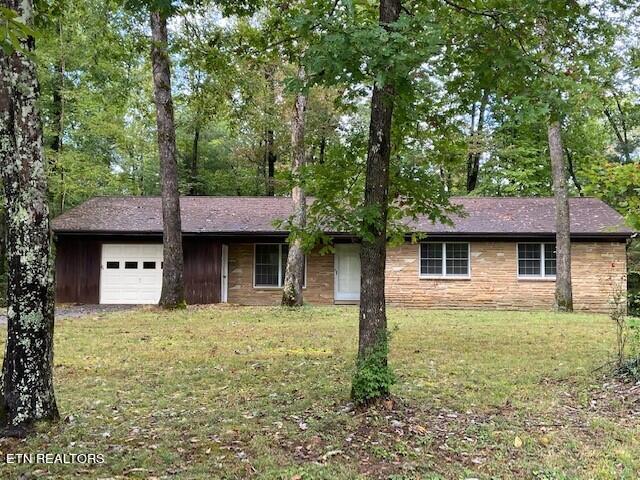 single story home with a front lawn and a garage