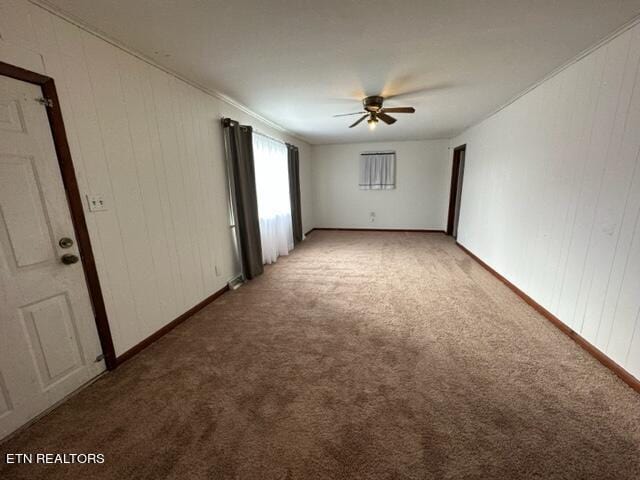 spare room featuring carpet, crown molding, and ceiling fan