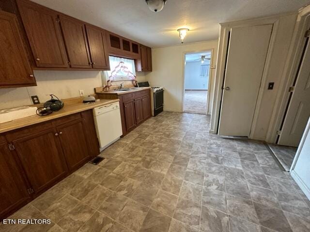 kitchen featuring stove, white dishwasher, and ceiling fan