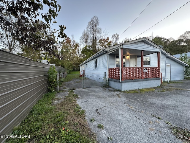 252 Chasteen Dr, Middlesboro, KY 40965 - view of side of property with a gate, covered porch, fence, and asphalt driveway