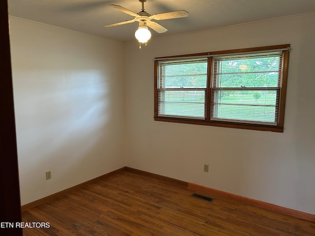 unfurnished room with ceiling fan and dark wood-type flooring