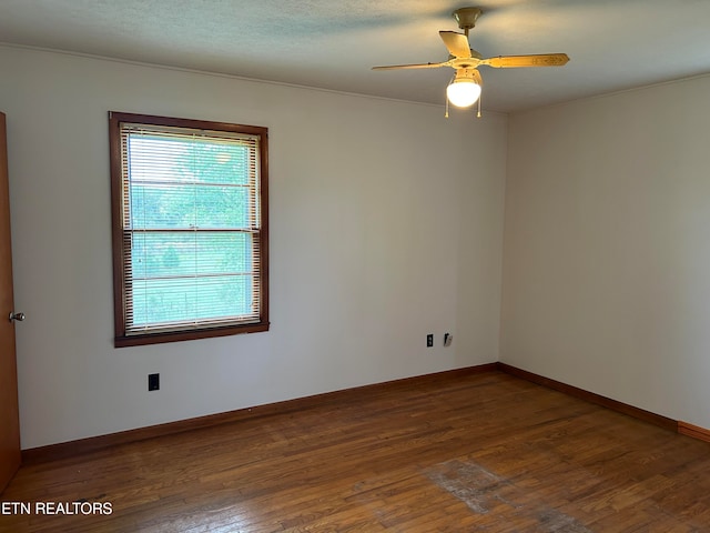 unfurnished room with ceiling fan, a wealth of natural light, and dark wood-type flooring