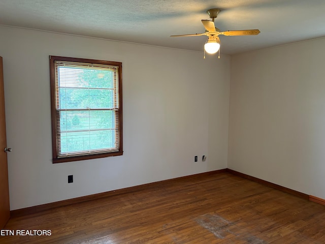 spare room featuring ceiling fan and dark wood-type flooring