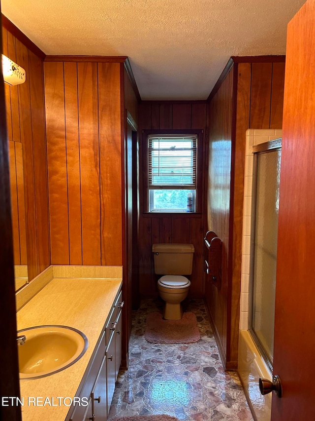 bathroom with toilet, wooden walls, tile floors, a textured ceiling, and large vanity