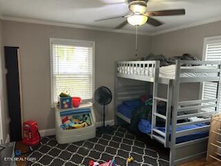 bedroom with ceiling fan and crown molding