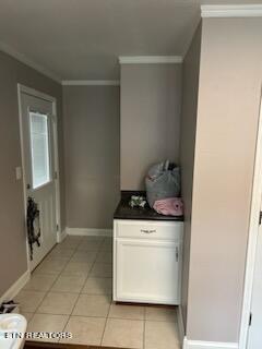 interior space featuring crown molding and light tile floors