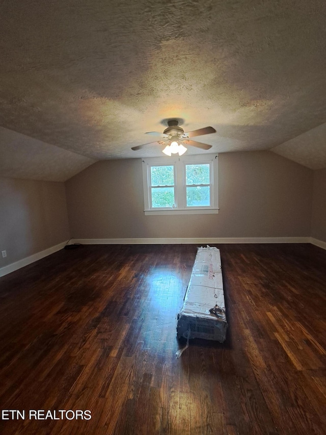 additional living space with dark hardwood / wood-style flooring, ceiling fan, lofted ceiling, and a textured ceiling