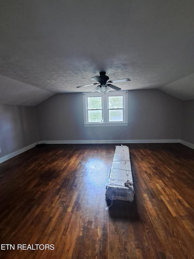 additional living space featuring dark wood-type flooring, ceiling fan, a textured ceiling, and lofted ceiling