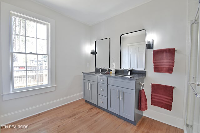 full bath with a sink, wood finished floors, and a shower with door