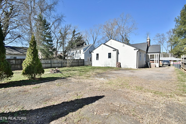 rear view of property with fence and a chimney