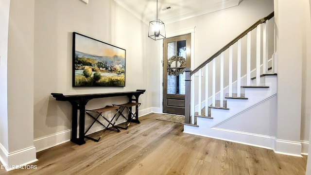 entrance foyer featuring stairway, visible vents, baseboards, and wood finished floors