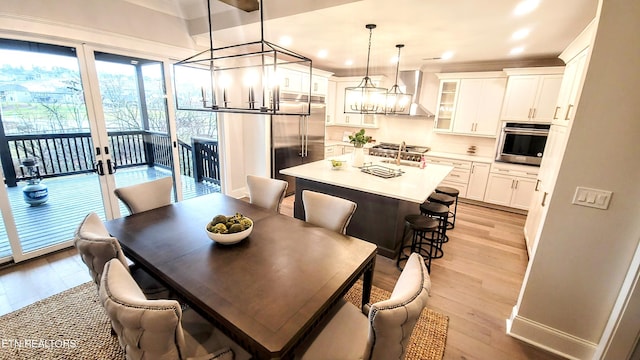 dining room with recessed lighting, light wood-style flooring, and baseboards