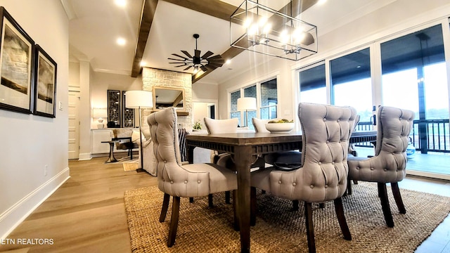 dining room with ornamental molding, light wood-type flooring, beamed ceiling, baseboards, and ceiling fan with notable chandelier