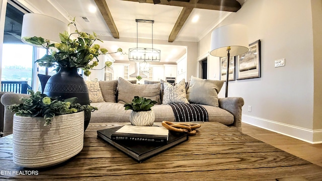 interior space featuring a chandelier, beamed ceiling, wood finished floors, and baseboards