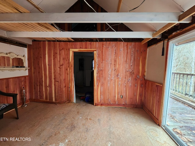 interior space featuring vaulted ceiling and wood walls