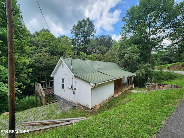 view of side of home with a yard and a deck