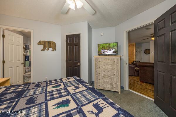 carpeted bedroom with connected bathroom, a textured ceiling, and ceiling fan