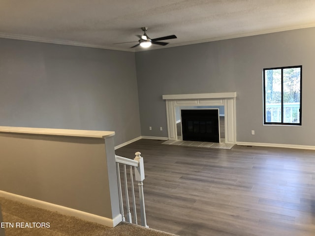 unfurnished living room with a textured ceiling, dark hardwood / wood-style flooring, ceiling fan, and ornamental molding