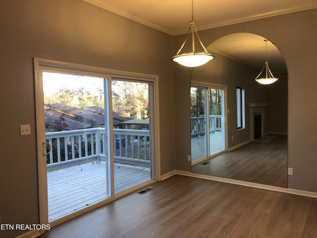 unfurnished dining area featuring dark hardwood / wood-style flooring, ornamental molding, and a wealth of natural light