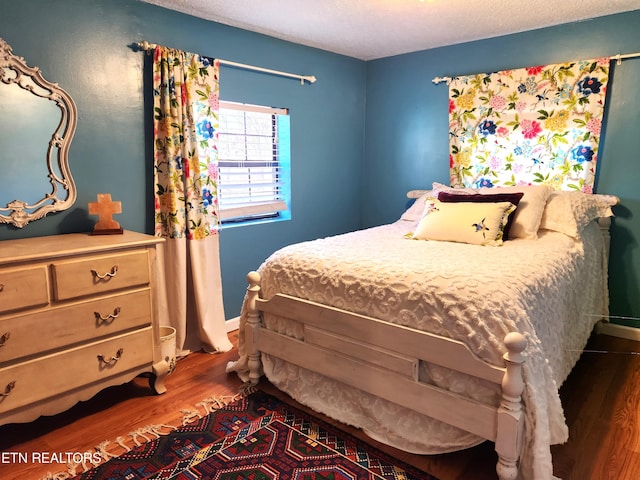 bedroom featuring dark hardwood / wood-style floors and a textured ceiling