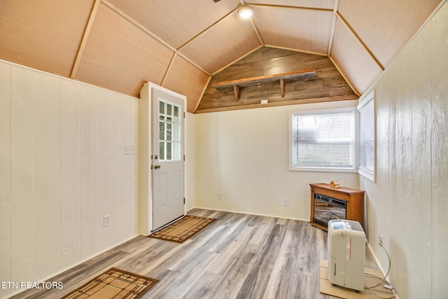 entryway featuring lofted ceiling, wood ceiling, wooden walls, and light hardwood / wood-style flooring