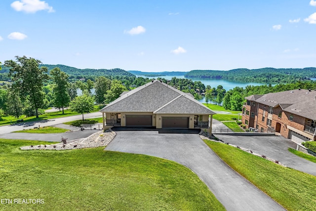 view of front facade with a water view, a garage, and a front lawn