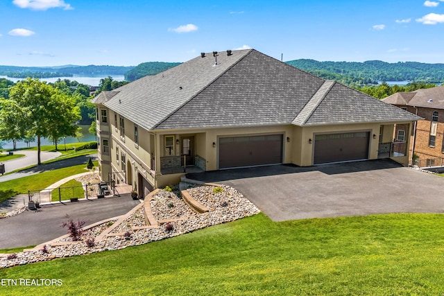 single story home featuring a garage, a mountain view, and a front lawn