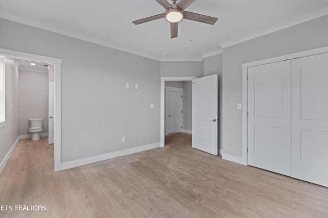 unfurnished bedroom featuring ceiling fan, light hardwood / wood-style floors, crown molding, and ensuite bathroom