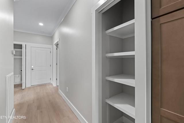 hallway featuring crown molding and light wood-type flooring