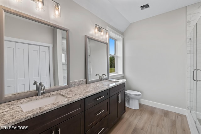 bathroom featuring double sink, a shower with shower door, wood-type flooring, large vanity, and toilet