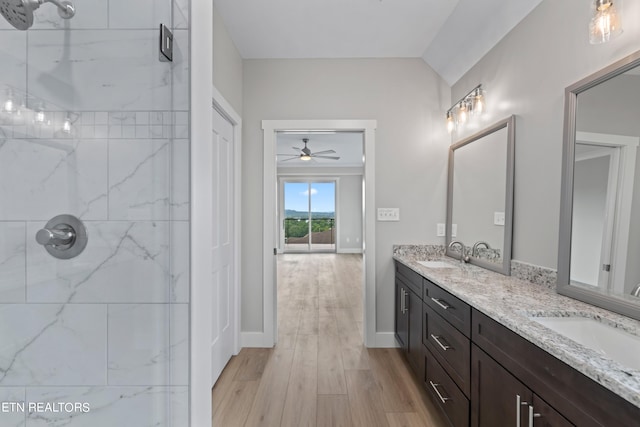 bathroom featuring a tile shower, ceiling fan, double sink vanity, and hardwood / wood-style flooring