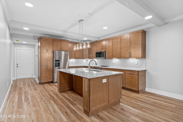 kitchen with light hardwood / wood-style floors, a center island with sink, appliances with stainless steel finishes, decorative light fixtures, and tasteful backsplash