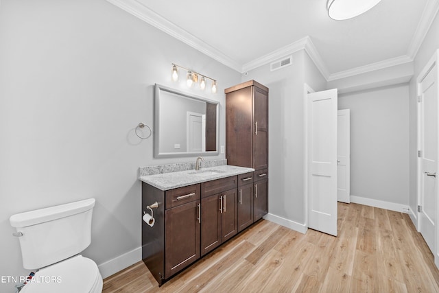 bathroom featuring ornamental molding, hardwood / wood-style floors, toilet, and vanity