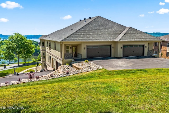 exterior space with a garage, a mountain view, and a lawn