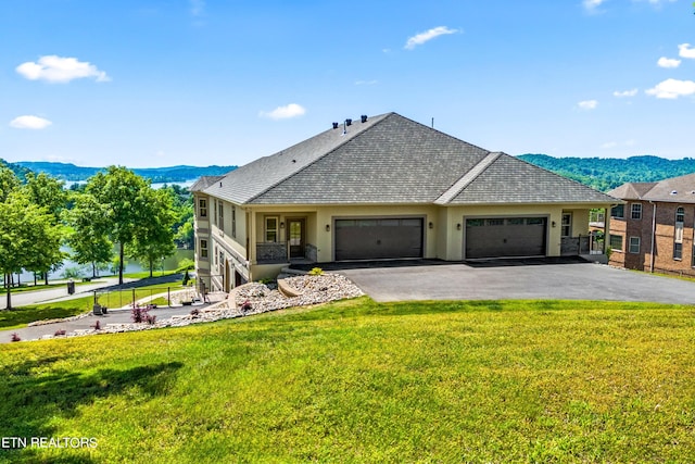 view of front of house with a garage, a mountain view, and a front yard