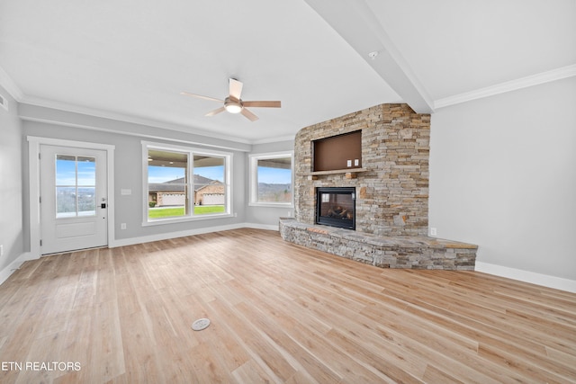 unfurnished living room with a stone fireplace, ceiling fan, beamed ceiling, and light wood-type flooring