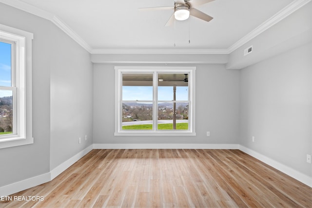 spare room with a healthy amount of sunlight, ornamental molding, and light wood-type flooring