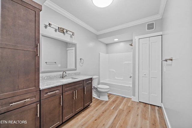 full bathroom featuring oversized vanity,  shower combination, wood-type flooring, ornamental molding, and toilet