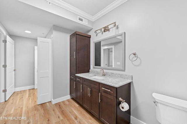 bathroom featuring crown molding, hardwood / wood-style floors, toilet, and large vanity