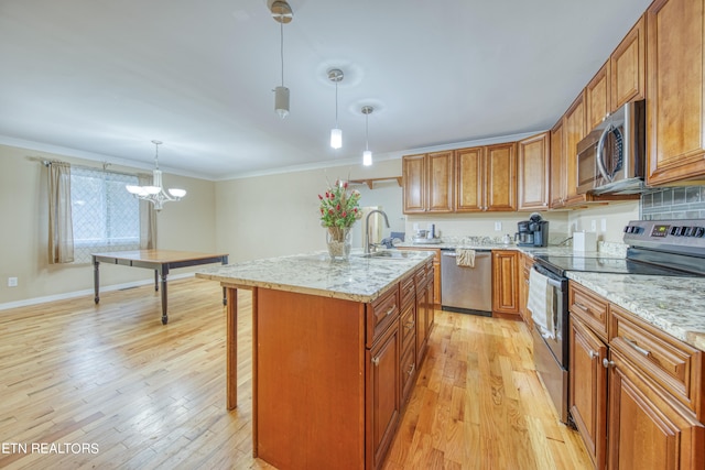 kitchen with a chandelier, pendant lighting, light hardwood / wood-style floors, stainless steel appliances, and sink