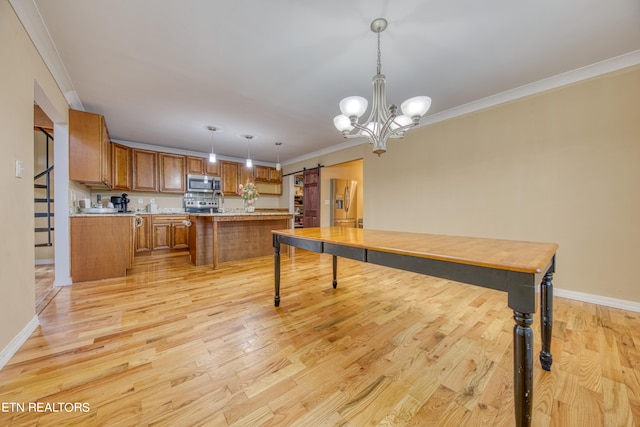 kitchen with appliances with stainless steel finishes, light wood-type flooring, decorative light fixtures, a barn door, and a chandelier