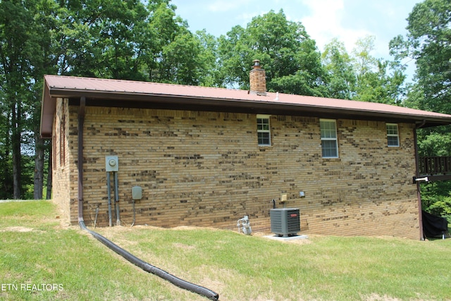 view of home's exterior with central AC and a yard