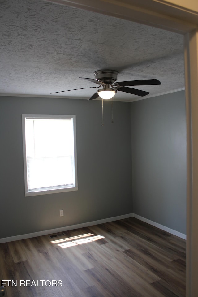 empty room with a textured ceiling, ceiling fan, and dark wood-type flooring