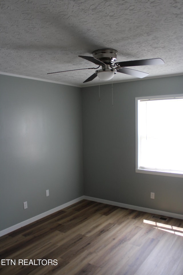 empty room with ceiling fan, dark hardwood / wood-style floors, and a textured ceiling