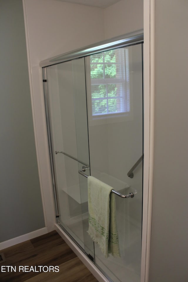 bathroom with hardwood / wood-style floors and walk in shower